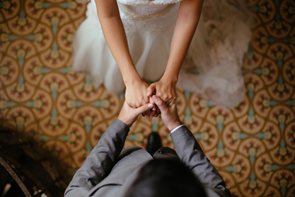 Two people holding hands at a wedding