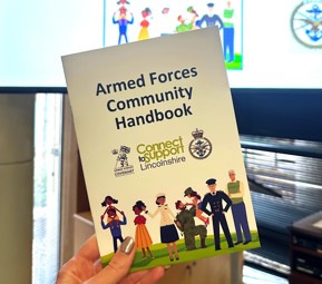 Photo of Armed Forces Community Handbook being held